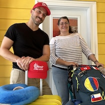 Julien Cadieux et Dounia Daoud debout derrière des bagages.