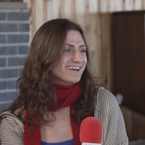 Xénia Gould tient un micro.