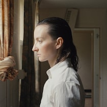 Une femme (Larissa Corriveau) de profil devant une fenêtre.