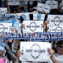 Vancouver Whitecaps fans hold signs before the first half of an MLS soccer match against the Colorado Rapids in Vancouver, on Saturday, April 25, 2026. THE CANADIAN PRESS/Ethan Cairns