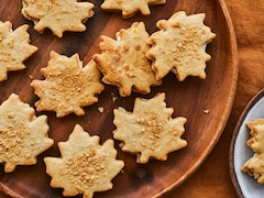 Des biscuits feuille d'érable dans une assiette ronde en bois.