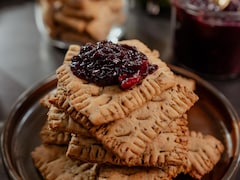Des biscuits empilés dans une assiette et garnis de confiture aux raisins.