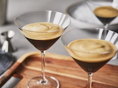 Trois verres d’espresso martini sans alcool sur un plateau de service.