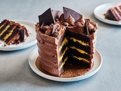 Un gâteau au chocolat à plusieurs couches garni de crème au fruit de la passion et de glaçage au chocolat.
