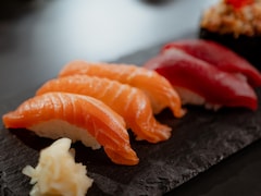 Des nigiris de saumon et de thon sur un plateau de service.