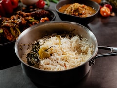 Une casserole de riz blanc avec des herbes et un piment habanero.