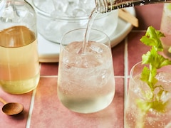 Trois verres de seltzer au thé du Labrador, avec un bol de glace, un verre de sirop et des branches de céleri. 