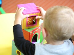 Un enfant de dos joue avec des blocs dans une garderie.