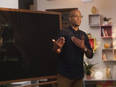 Le rappeur Webster (Aly Ndiaye) est devant un tableau dans une classe. 