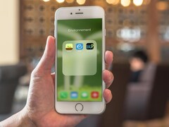 Trois applis écolo sur un écran de iPhone dans un café. 