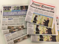 Six journaux de 2017 étalés sur une table : trois copies du Telegraph-Journal et trois du Times & Transcript.