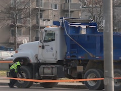 Un policier inspecte le camion-benne de la Ville de Québec. 