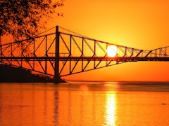 Vue sur le pont de Québec avec en arrière-plan, un soleil couchant.
