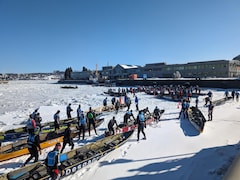 Tout près d'un quai du port de Québec, des dizaines d'athlètes se préparent à diriger leur canot dans les glaces mouvantes du fleuve Saint-Laurent. 