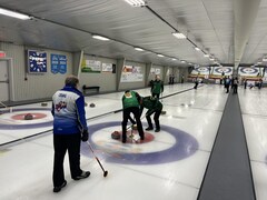 Des joueurs de curling sur une glace pendant une partie.
