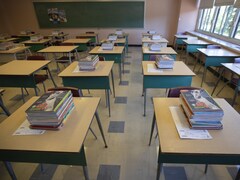 Des livres sont empilés sur les bureaux dans une salle de classe.