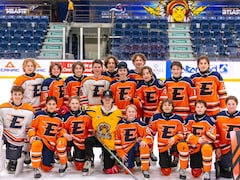Des jeunes joueurs de hockey placé pour prendre une photo d'équipe.