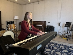 Une personne joue du piano dans un studio.