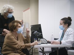Janette Bertrand parle avec une préposée avant de se faire vacciner.