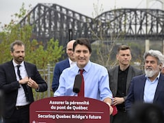 Justin Trudeau en conférence de presse avec le pont de Québec en arrière plan.