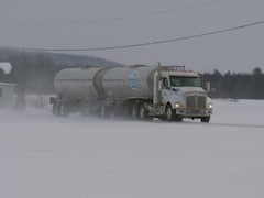 Un camion-citerne transportant du lait sur une route de campagne en hiver.