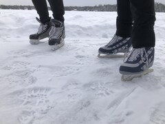 Deux personnes en patin sur l'anneau de glace.