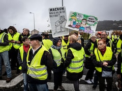 Des manifestants tiennent des pancartes sur lesquelles on peut lire «Macron, ras le bol de ta politique».