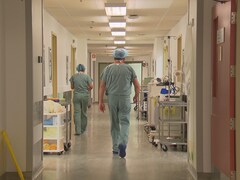 Un médecin  marche dans un corridor d'hôpital