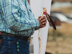 Un homme, dont on ne voit que le torse, se recueille lors d'une cérémonie autochtone. 