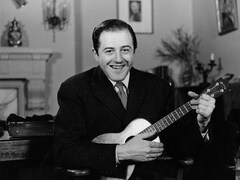 Le chanteur Raymond Lévesque, une guitare à la main, dans le salon de sa résidence.
