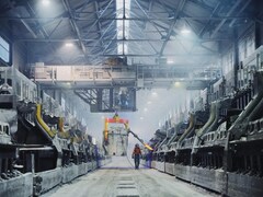Un homme marche dans une usine d'aluminium