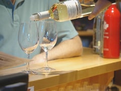 Un vin blanc du vignoble St Hubertus est versé dans un verre à vin.