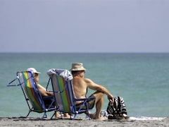 Un homme et une femme assis sur des chaises à la plage.