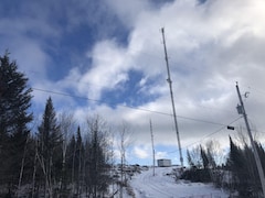 Une tour de télécommunication sur une montagne enneigée.