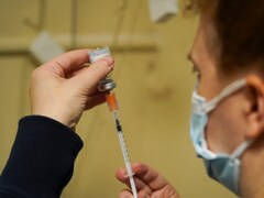 Un infirmier remplit une seringue à partir d'une fiole de vaccin.