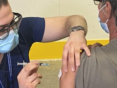 Une personne administre une dose du vaccin d'AstraZeneca.