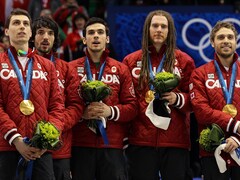 Guillaume Bastille, Charles et François Hamelin, Olivier Jean et François-Louis Tremblay se tiennent debout sur le podium après avoir remporté l'or au relais 5000 m masculin, en patinage de vitesse courte piste, aux Jeux olympiques de Vancouver en 2010.
