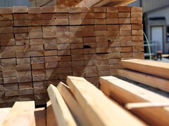Plan rapproché sur des piles de bois d'œuvre en format de planche de 2 pouces par 4 pouces. 