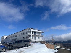Une école dans un décor montagneux d'hiver.