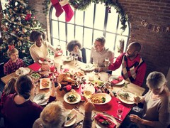 Une famille et des amis réunis autour d'une dinde du temps des Fêtes.