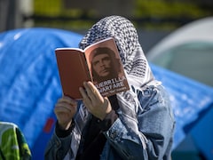 Une manifestante pro-palestinienne lit un livre au campement à l'UBC. le 2 mai 2024. 