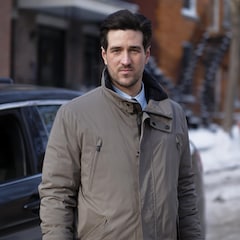 Danno Boulianne (Olivier Gervais-Courchesne) devant une voiture, il porte un manteau d'hiver, il regarde la caméra.