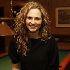 Le personnage de Judith Morency, interprété par Caroline Bouchard, sourit à la caméra tout en étant assise sur une table de billard.