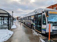 Des autobus arrêtés à un terminus au centre-ville de Trois-Rivières.