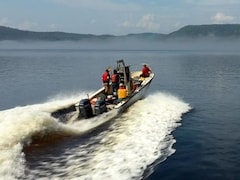 Des spécialistes se promènent en chaloupe sur Le fjord du Saguenay.