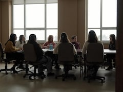 Des femmes discutent autour d'une table dans une salle de réunion.