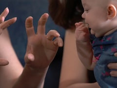 Un bébé qui regarde des mains.