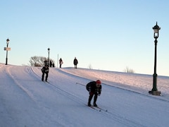 Des personnes descendent une pente enneigée à l'aide de skis.