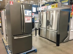 Des réfrigérateurs sont exposés dans un magasin à grande surface.