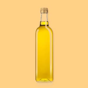 Une bouteille d'huile canola sur un fond jaune.